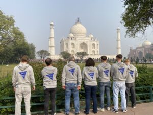 Gruppenfoto vor dem Taj Mahal mit dem Rücken zur Kamera um die neuen BSB Pullover mit dem Logo auf dem Rücken zu präsentieren