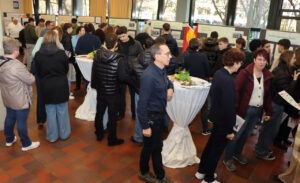 Besucher in der Aula vor den Präsentationswenden